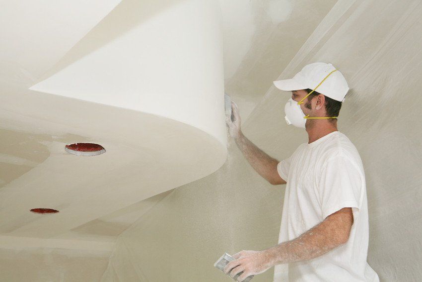 Worker sanding freshly dried sheetrock on a nice ceiling detail