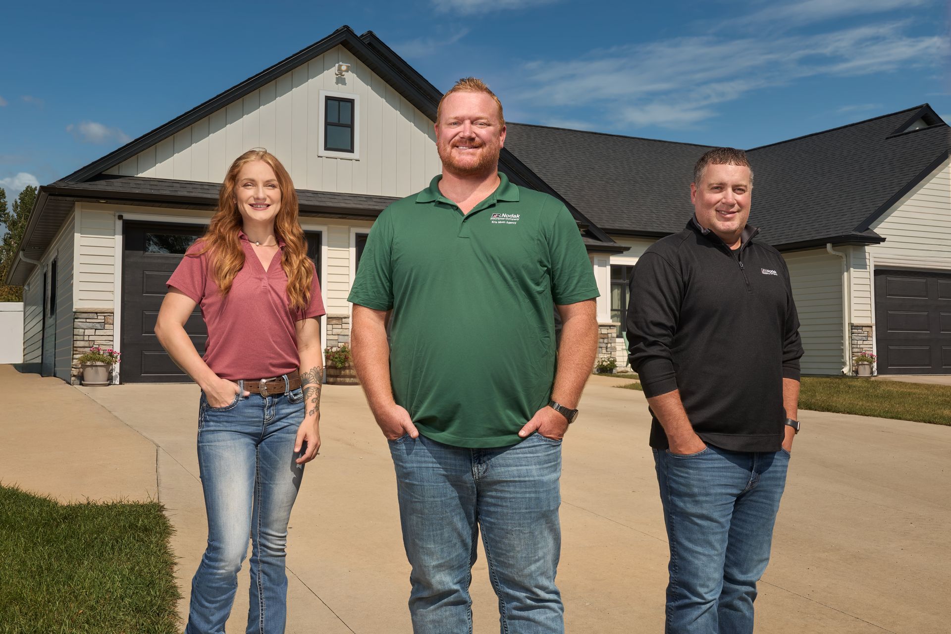 Two people smiling, listening to a person holding papers. Office setting.