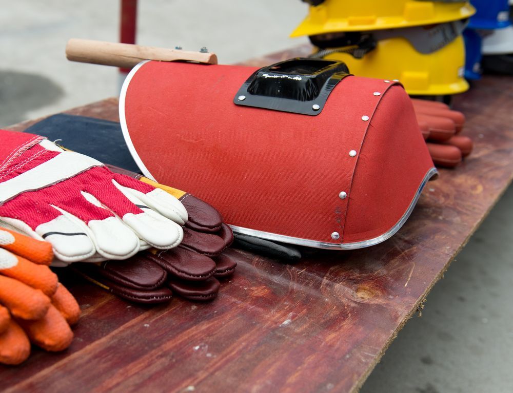 A Row of Hard Hats and Gloves on a Wooden Table — Outlaw Mechanical & Performance In Inverell, NSW