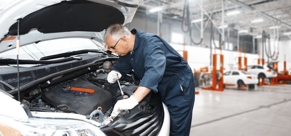 A Mechanic is Working Under the Hood of a Car in a Garage — Outlaw Mechanical & Performance In Inverell, NSW