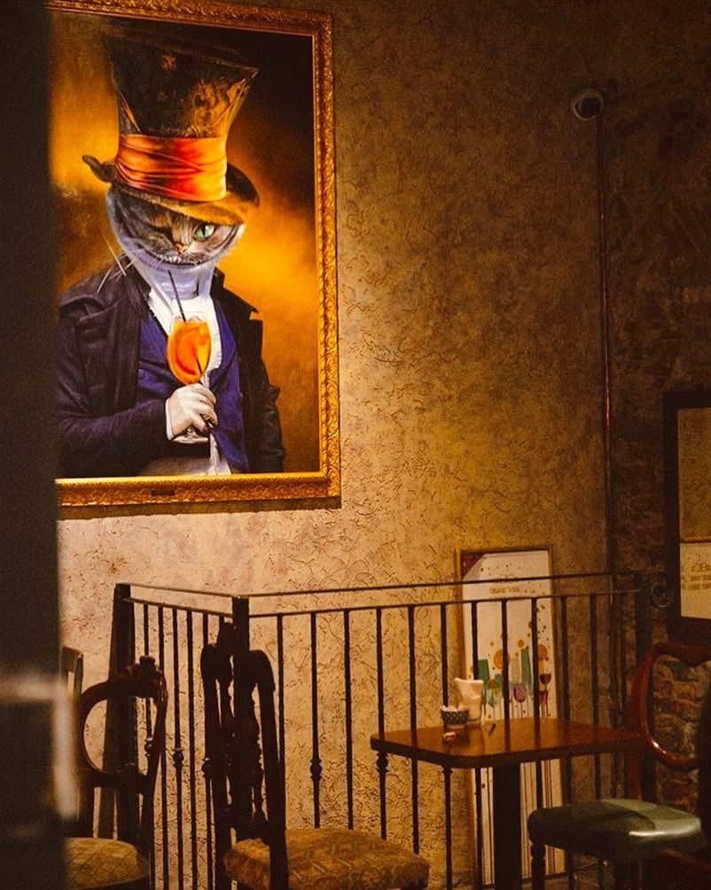 Persona che tiene in mano un hamburger sopra un piatto di insalata mista su un tavolo di legno.