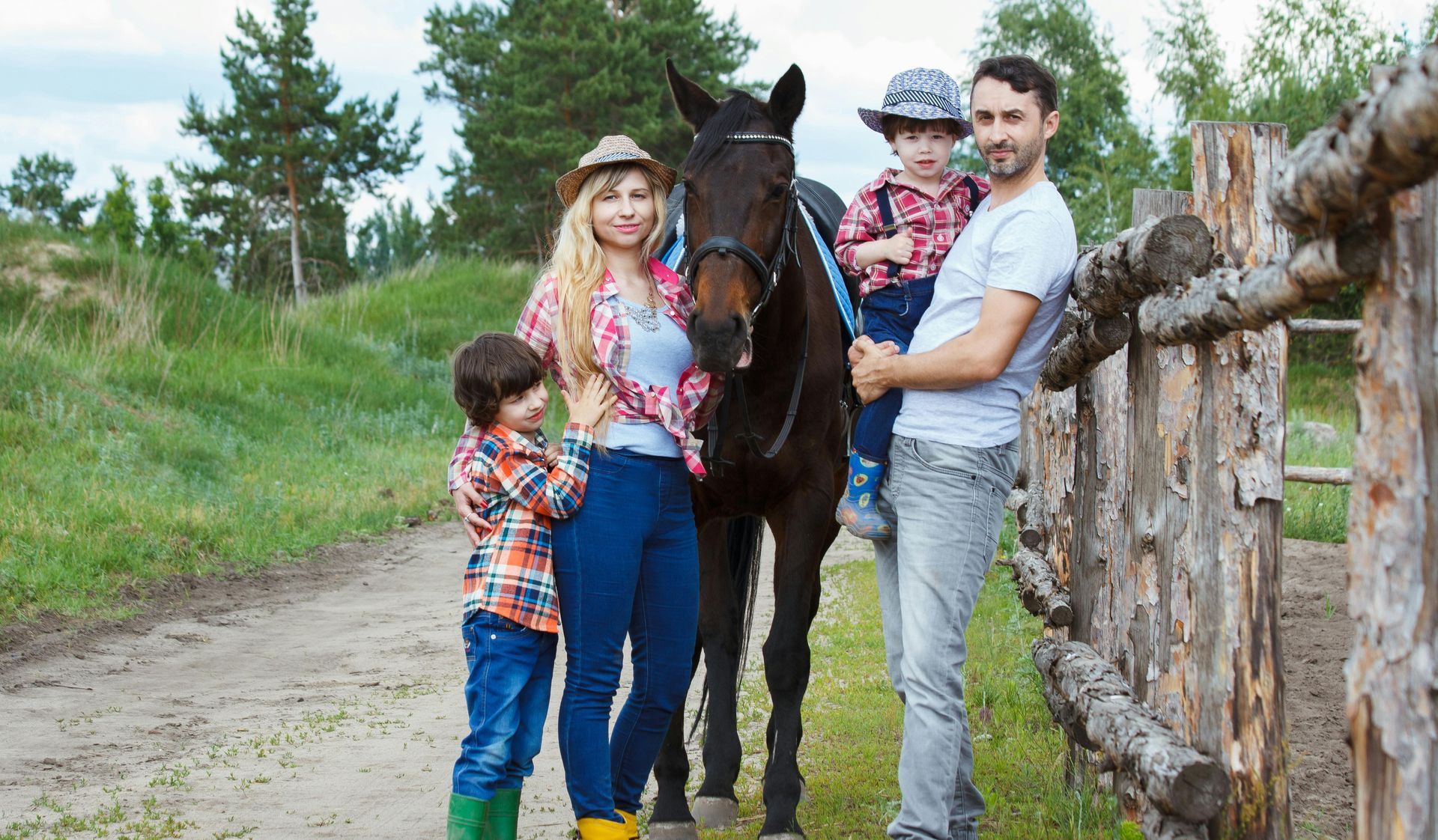 A family is standing next to a horse in a field.