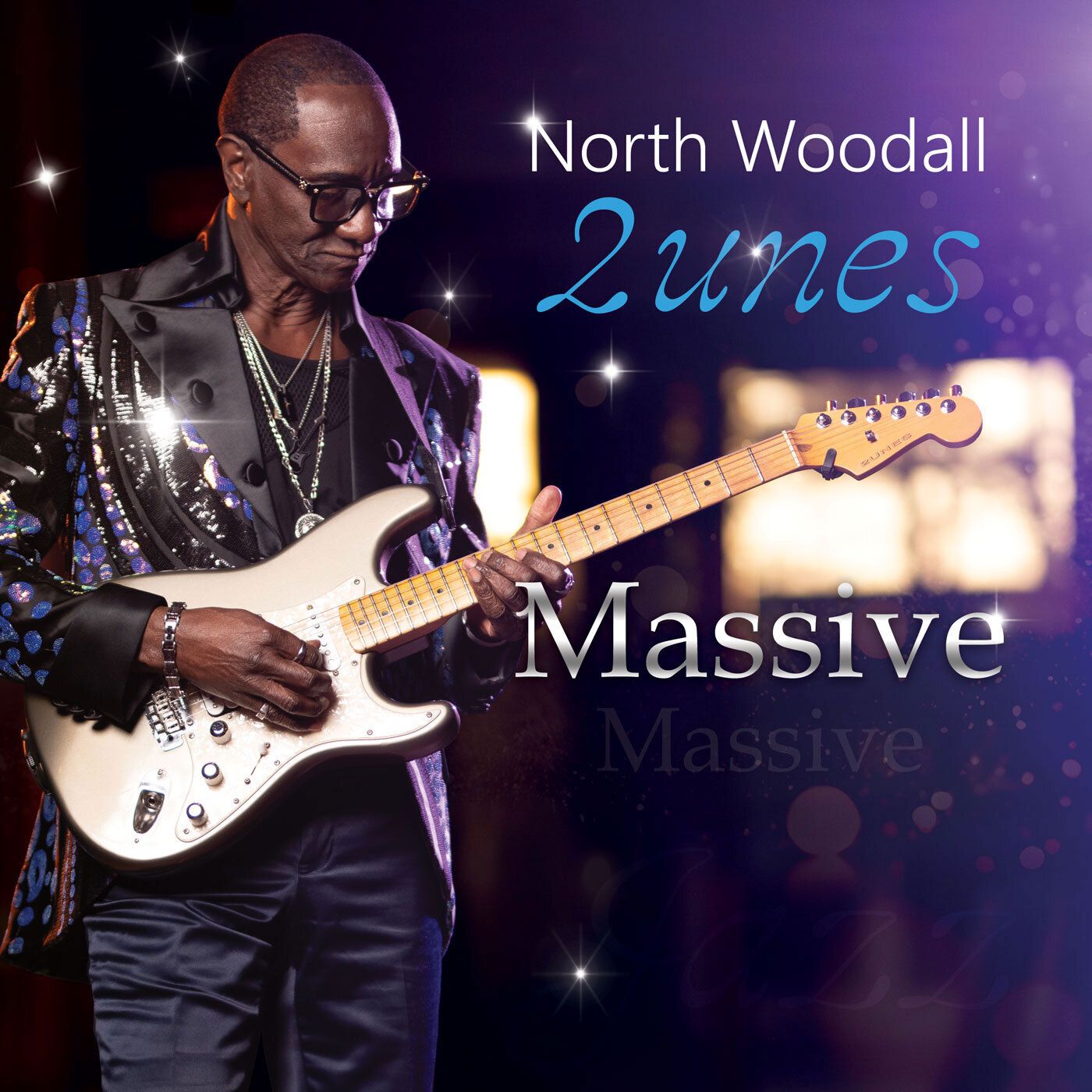 North Woodall playing a silver guitar, wearing a sequined jacket, on stage. Title: 