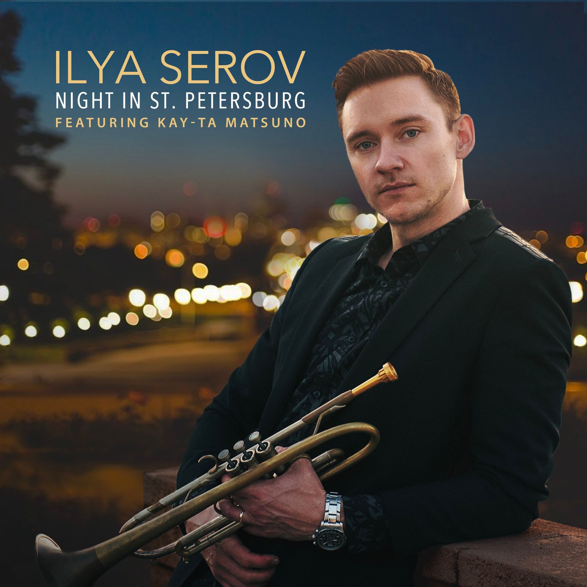 Ilya Serov holding a trumpet, posed in front of a night cityscape. He has red hair and wears a black suit.
