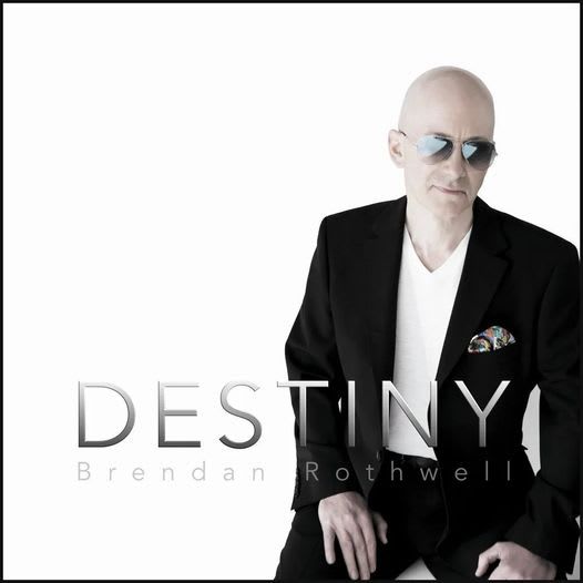 Brendan Rothwell album cover. Bald man in black suit and sunglasses, against white background. Text 