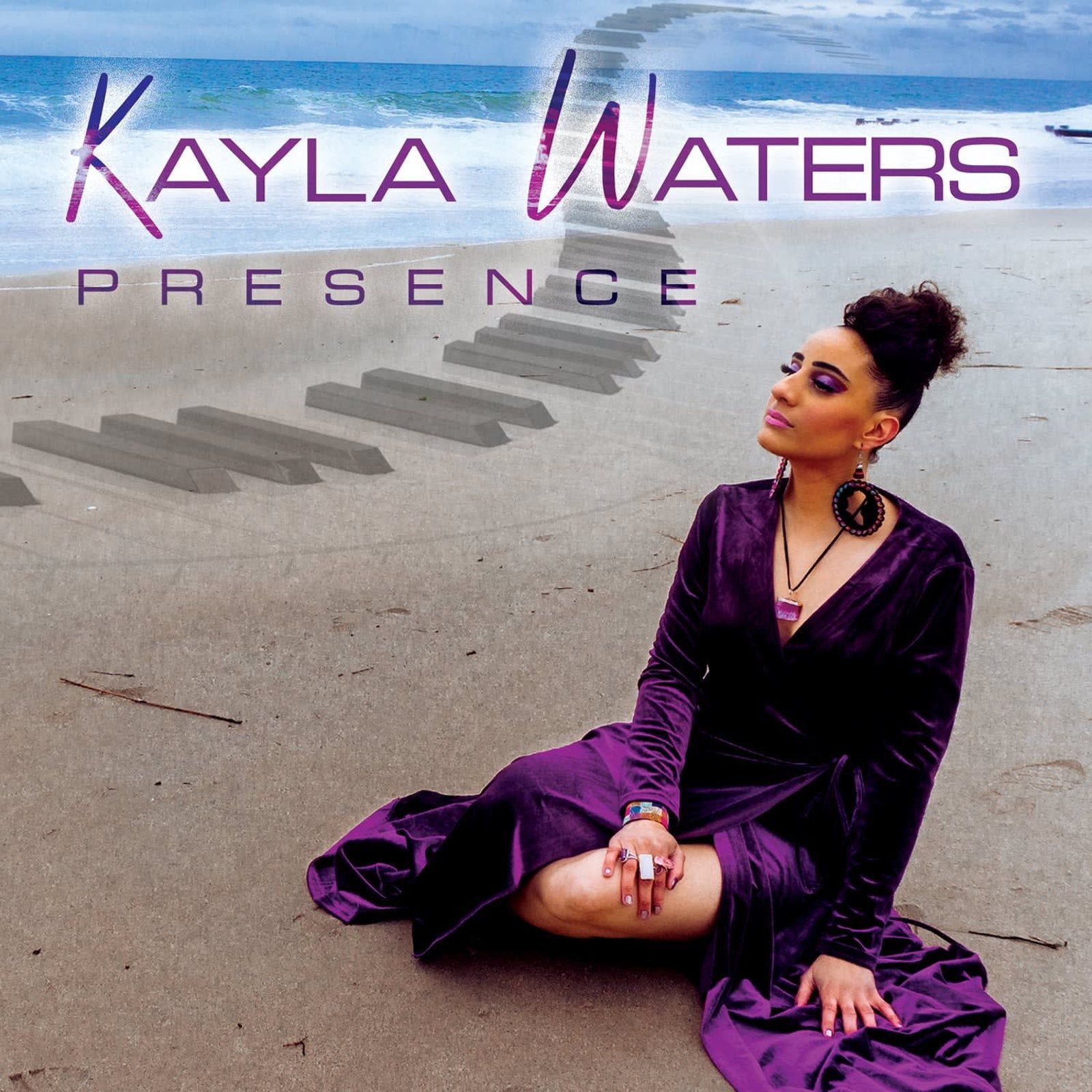 Kayla Waters album cover. Woman in purple on beach looking toward piano path leading to ocean.