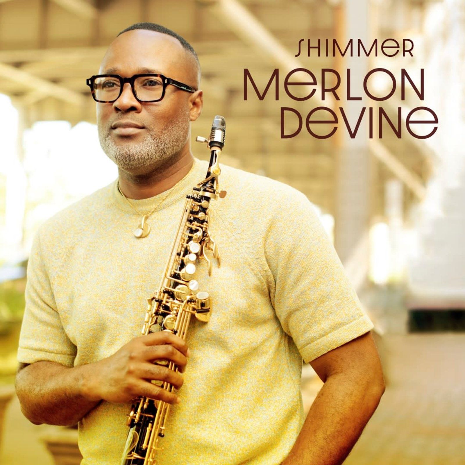 Merlon Devine holding saxophone, wearing glasses, in front of a bridge. Album cover for 