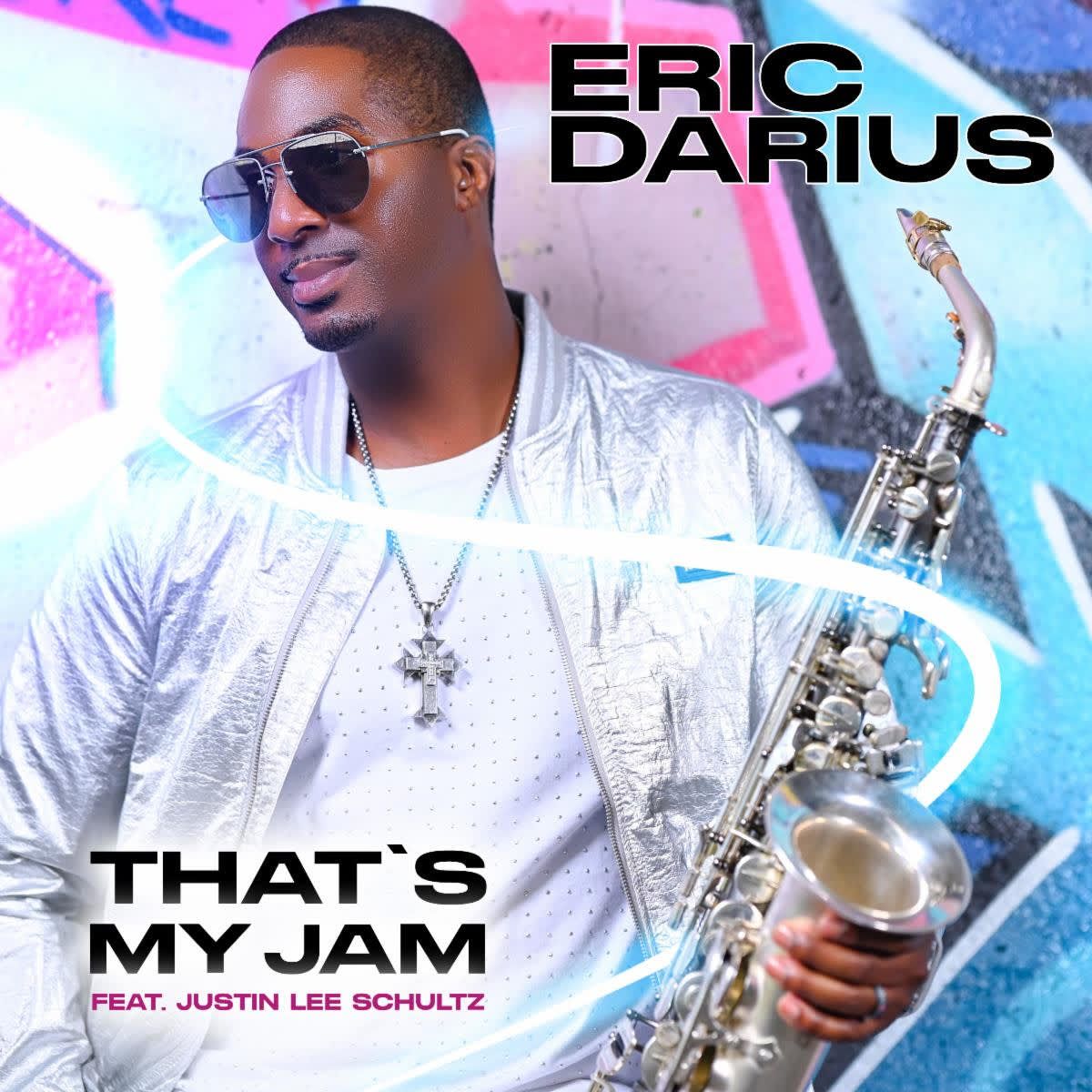 Eric Darius holding a saxophone, wearing sunglasses and a silver jacket. 