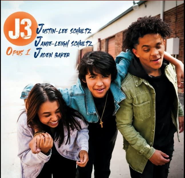 J3 album cover. Three smiling teens in denim and green jackets against a brick wall.
