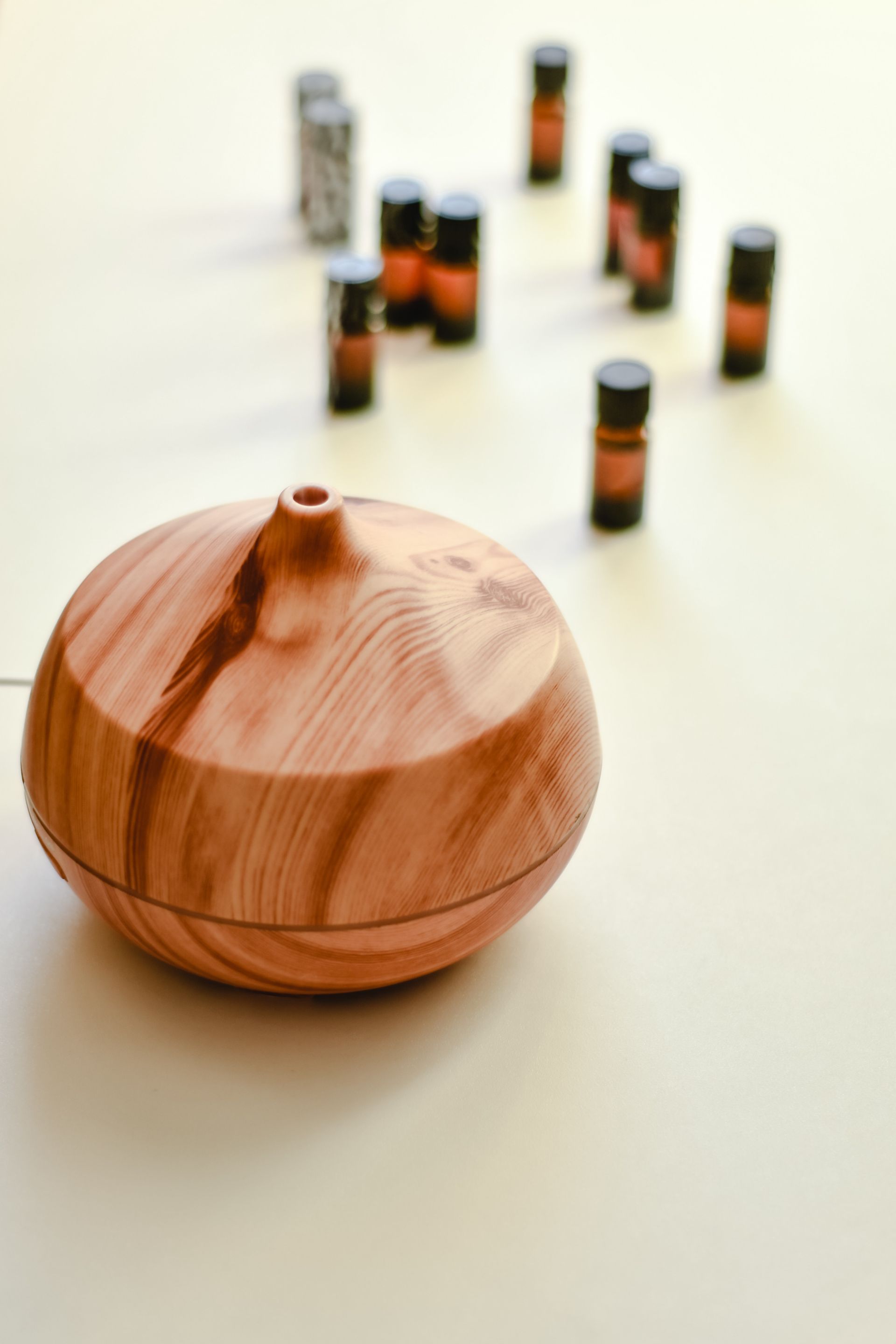 A wooden essential oil diffuser is sitting on a table next to bottles of essential oils.