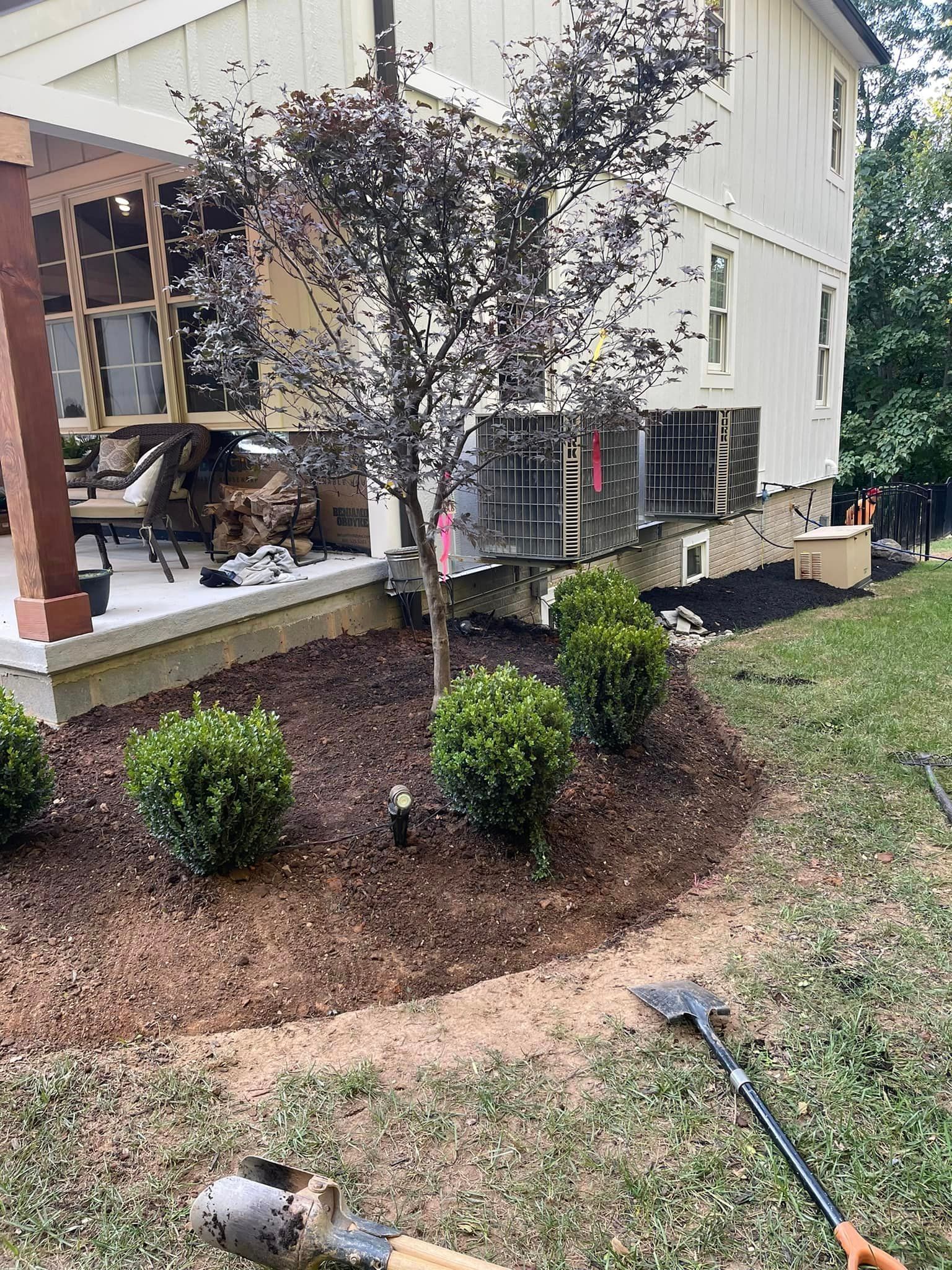 A house with a porch and a lawn mower in front of it.