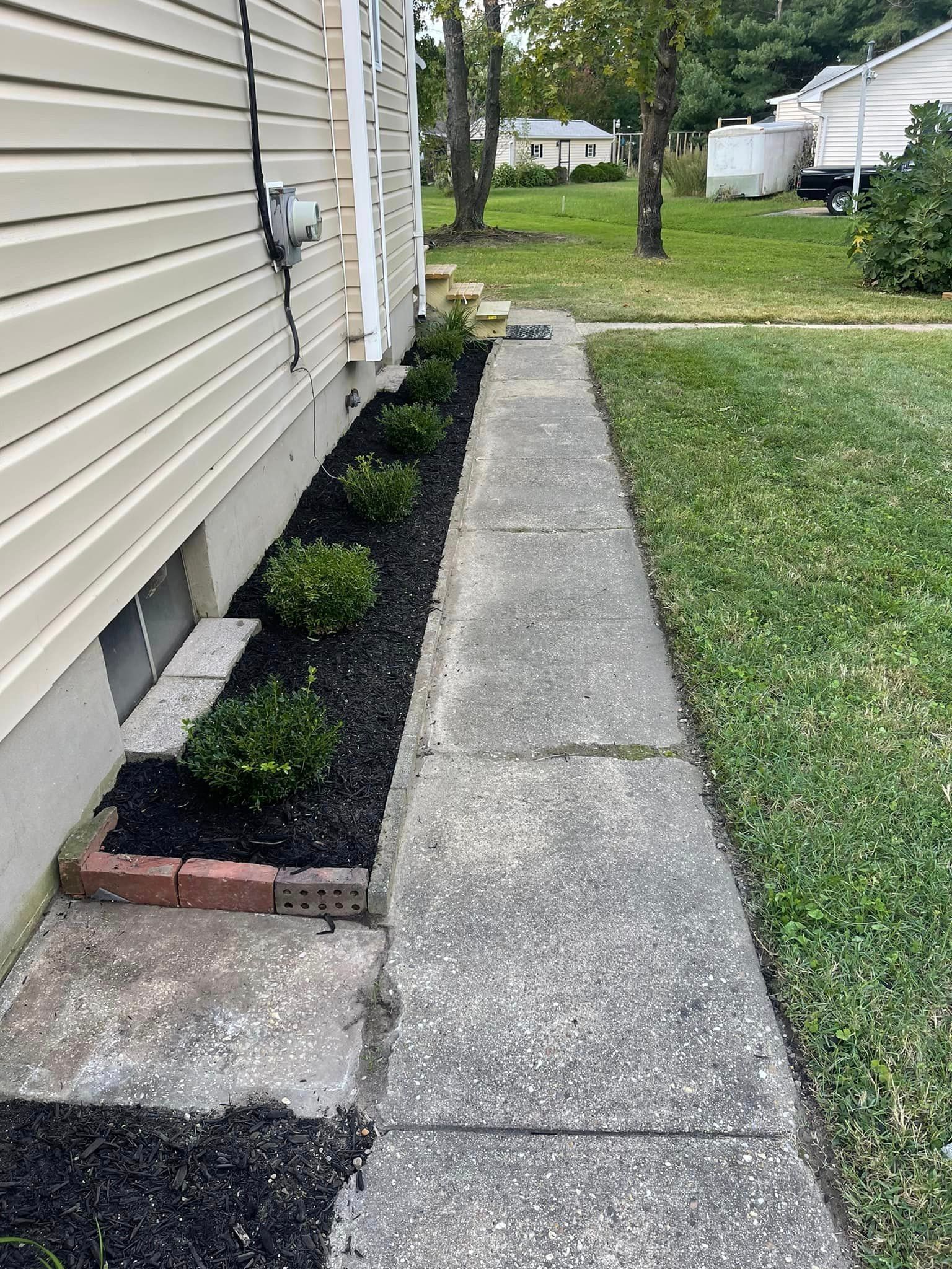 A sidewalk leading to a house with a lawn in the background.