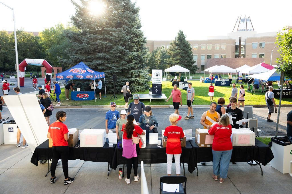 Zoomed out view of Guild volunteers manning the race registration table at Run for the Ring.