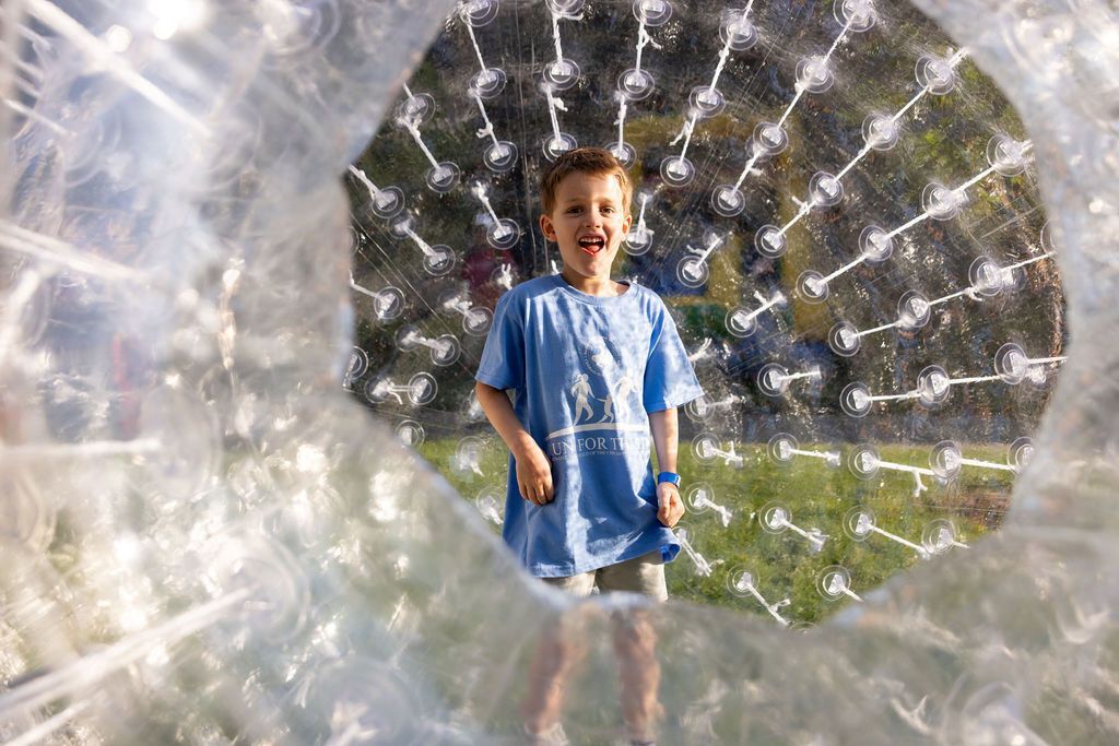 Young boy in his "I'm the 1" T-shirt inside of a human hamster ball in Kids Fun Zone.
