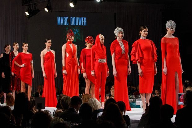 A group of women are walking down a runway wearing red dresses