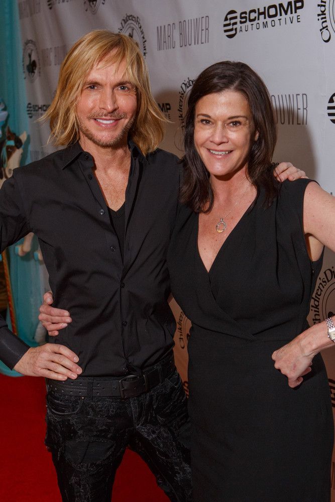 A man and a woman are posing for a picture on a red carpet.