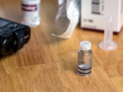 A small bottle of liquid is sitting on a wooden table.