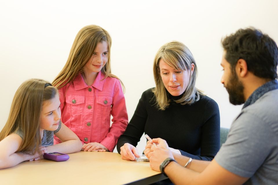 Mother and her two children sitting with a male counselor. 