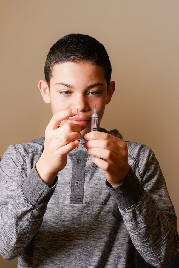 A young boy is holding a lighter in his hand.
