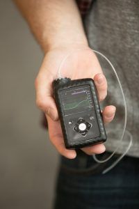 A person is holding a small device in their hand.