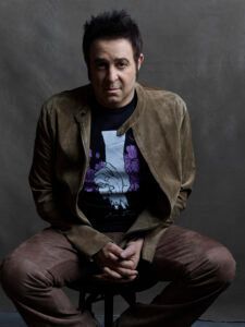 A man in a brown jacket is sitting on a chair