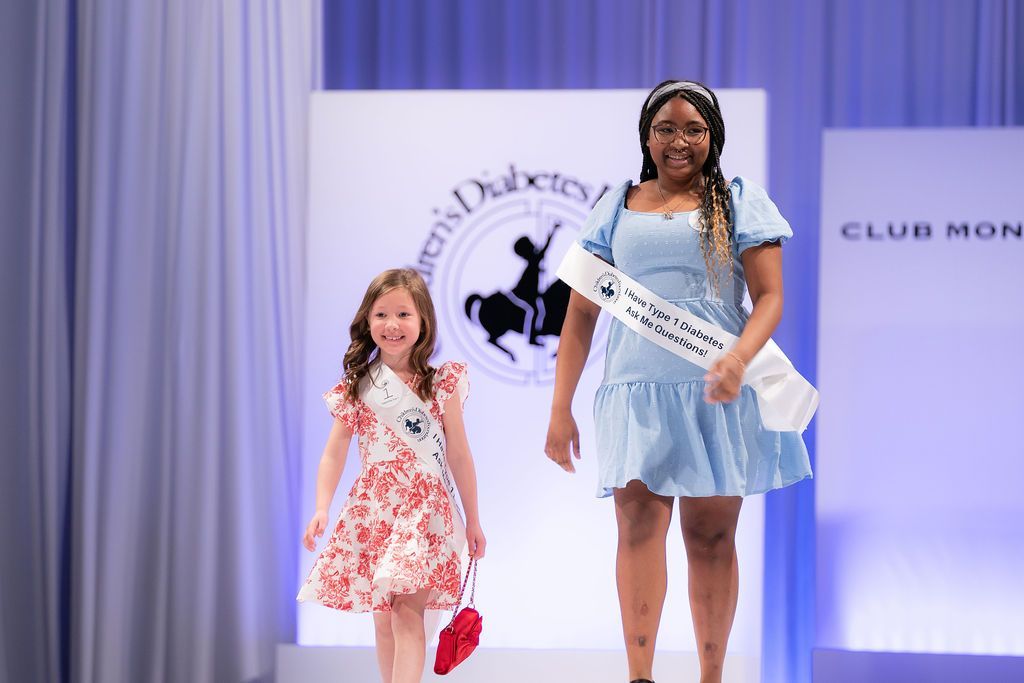 Two young female T1D Advocates walking the runway at the Brass Ring Luncheon and Fashion Show.