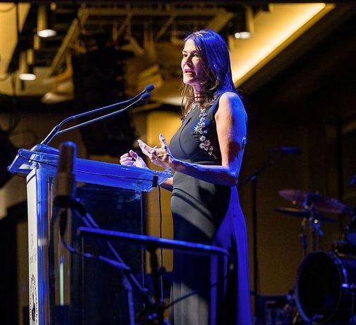 CDF Executive Director Dana Davis standing on stage giving a speech.