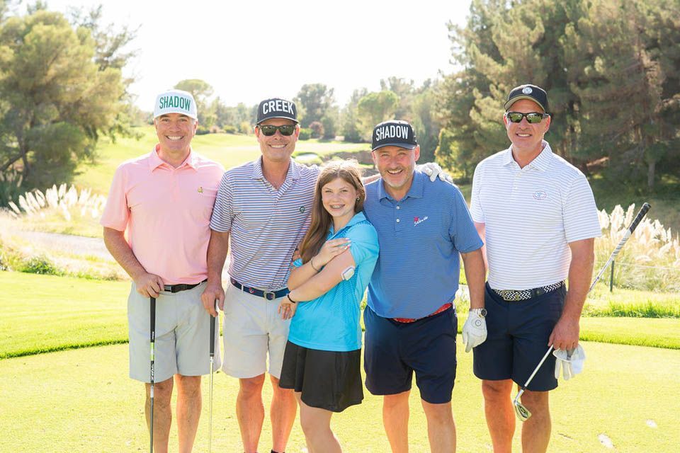 A group of people are posing for a picture on a golf course.