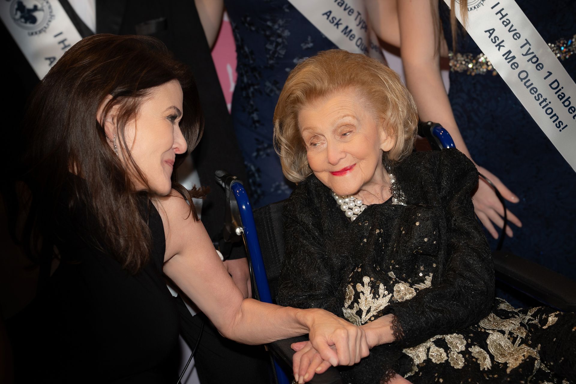 Dana Davis with her mother, Barbara Davis, smiling and holding hands at Carousel of Hope.