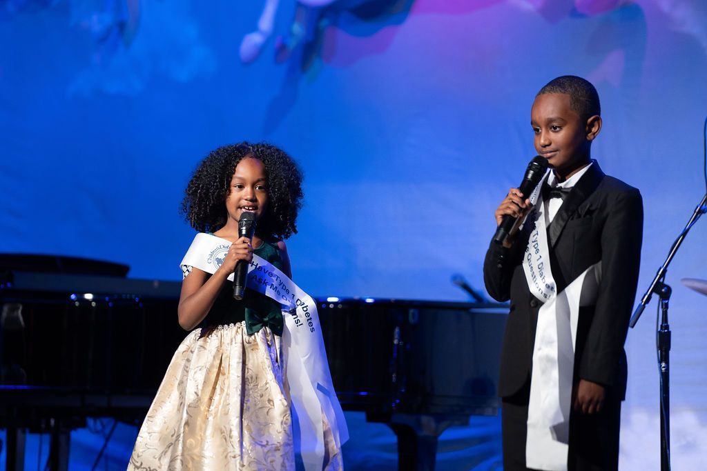 Sibling T1D Advocates and prayer children for the evening, on stage delivering their prayer.