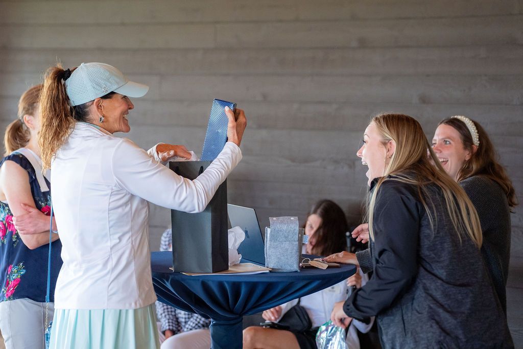 A group of women are standing around a table at a party.