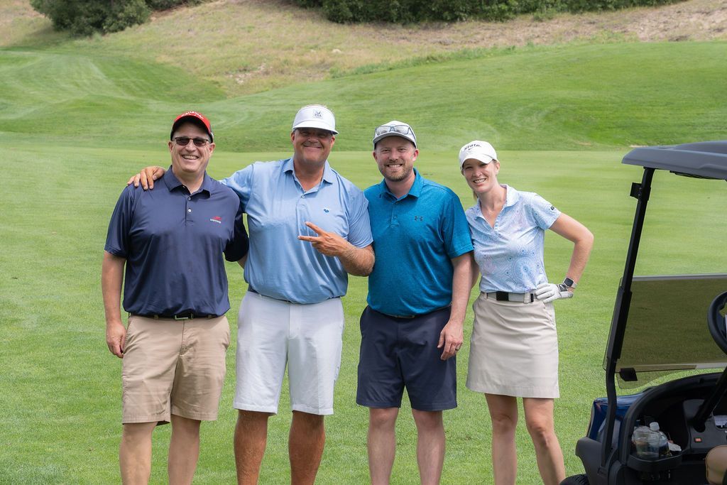 A group of people are posing for a picture on a golf course.