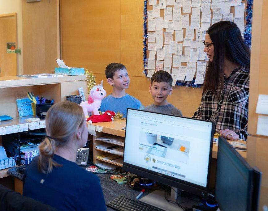 Family of mother and two young boys checking in for their doctor's appointment.