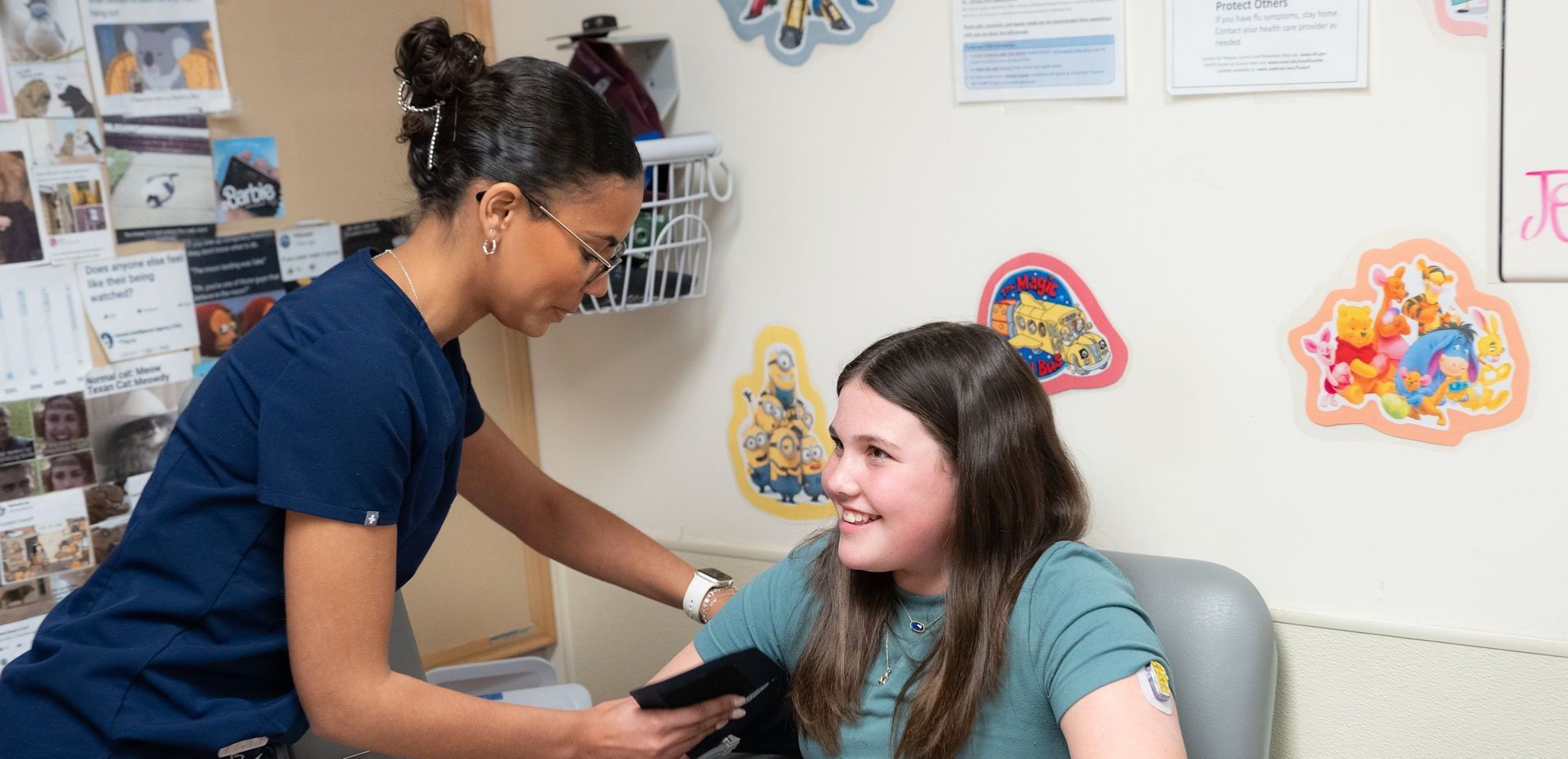 Female medical worker showing young boy how to put on his CGM.