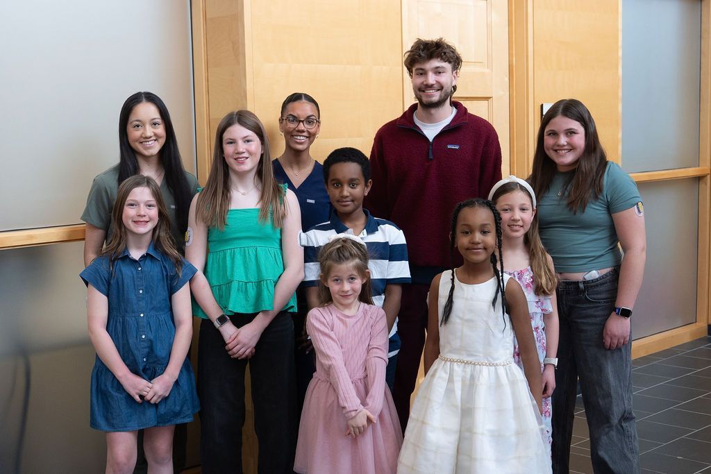 Group of smiling young T1D patients standing with medical staff at the Barbara Davis Center.