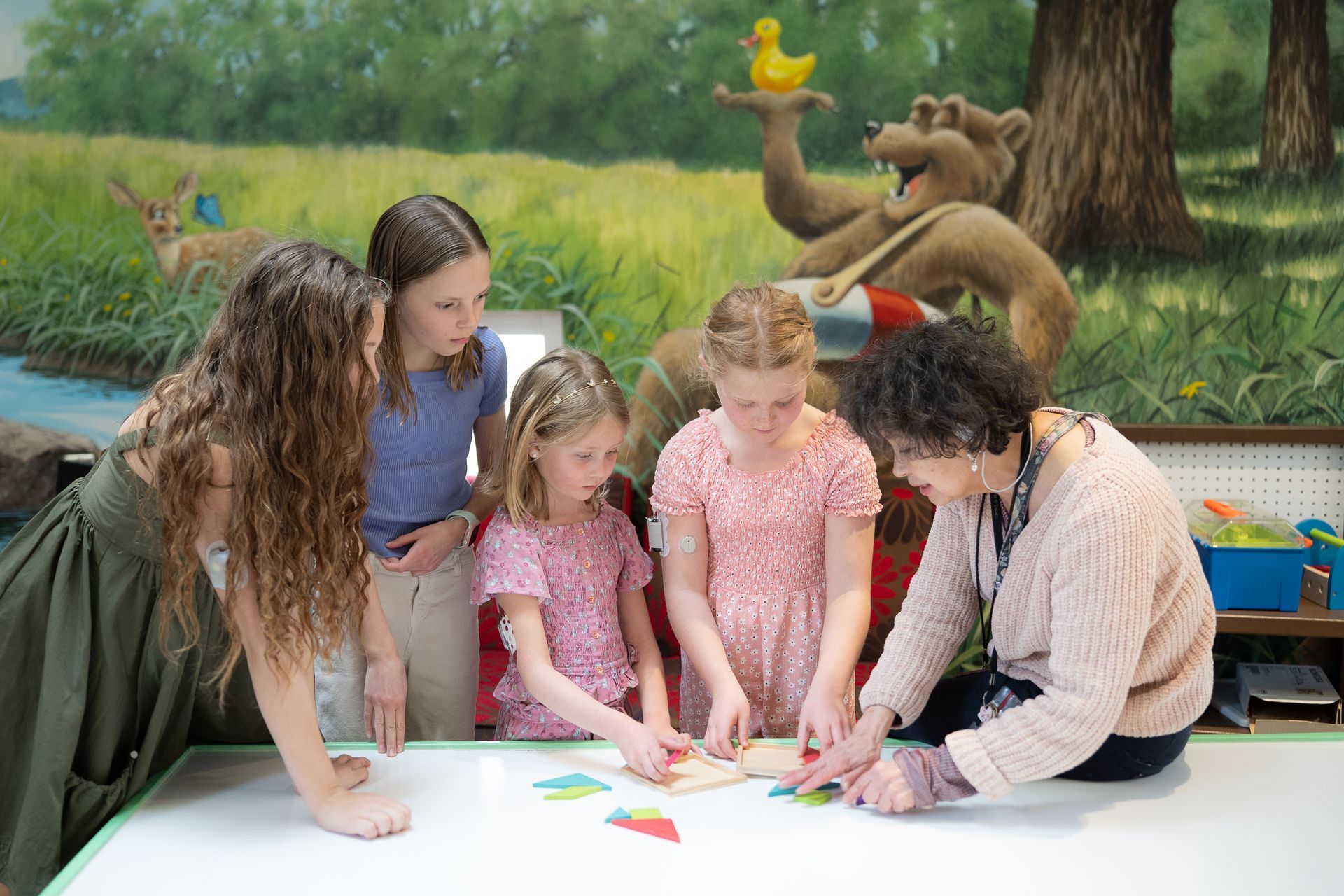 Female BDC staff member teaching group of four young T1D patients. 