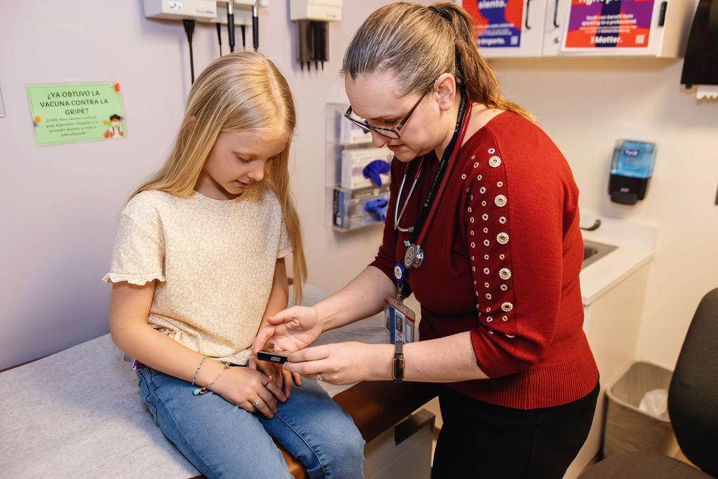 Female doctor examining young girl in medical exam room.
