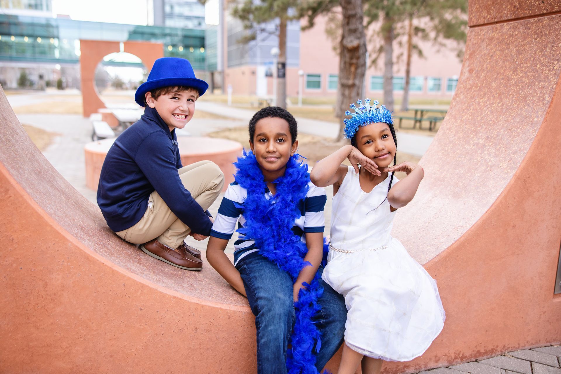 Three young T1D patients dressed up in blue accessories and posing during Diabetes Awareness Month.