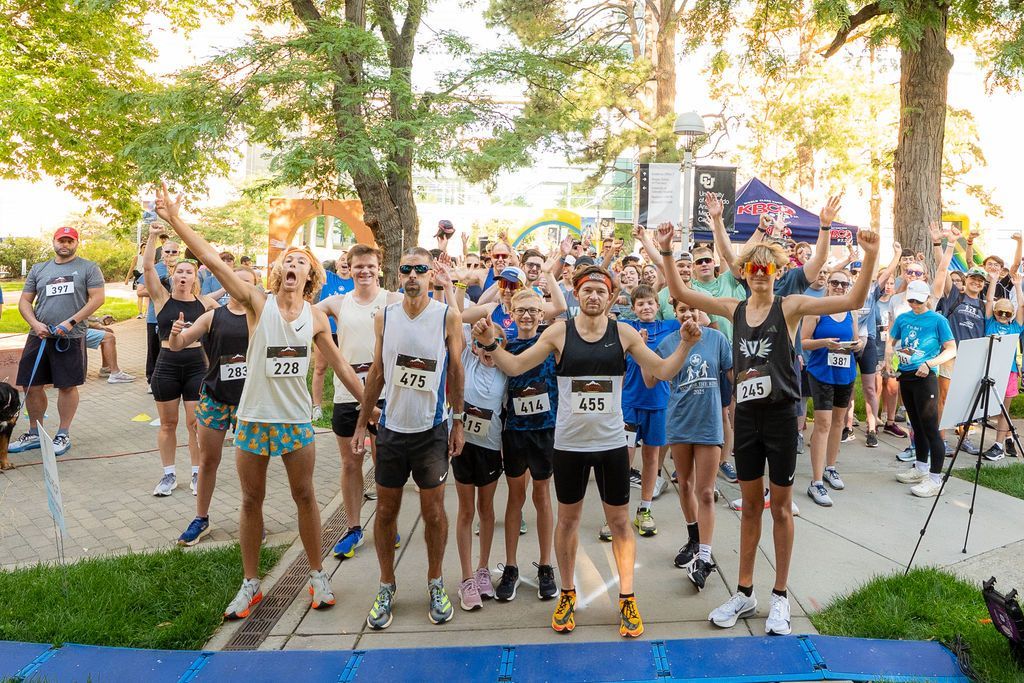group of runners in silly poses at start line of 5k