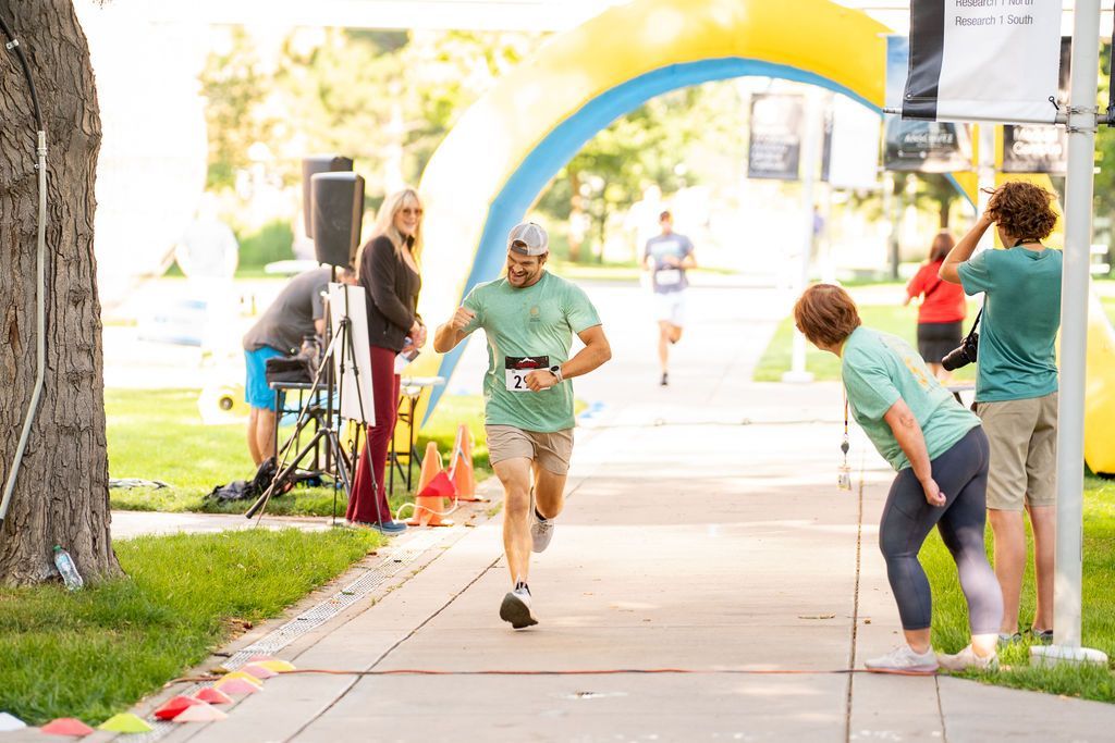 man finishing 5k race and fist pumping his time