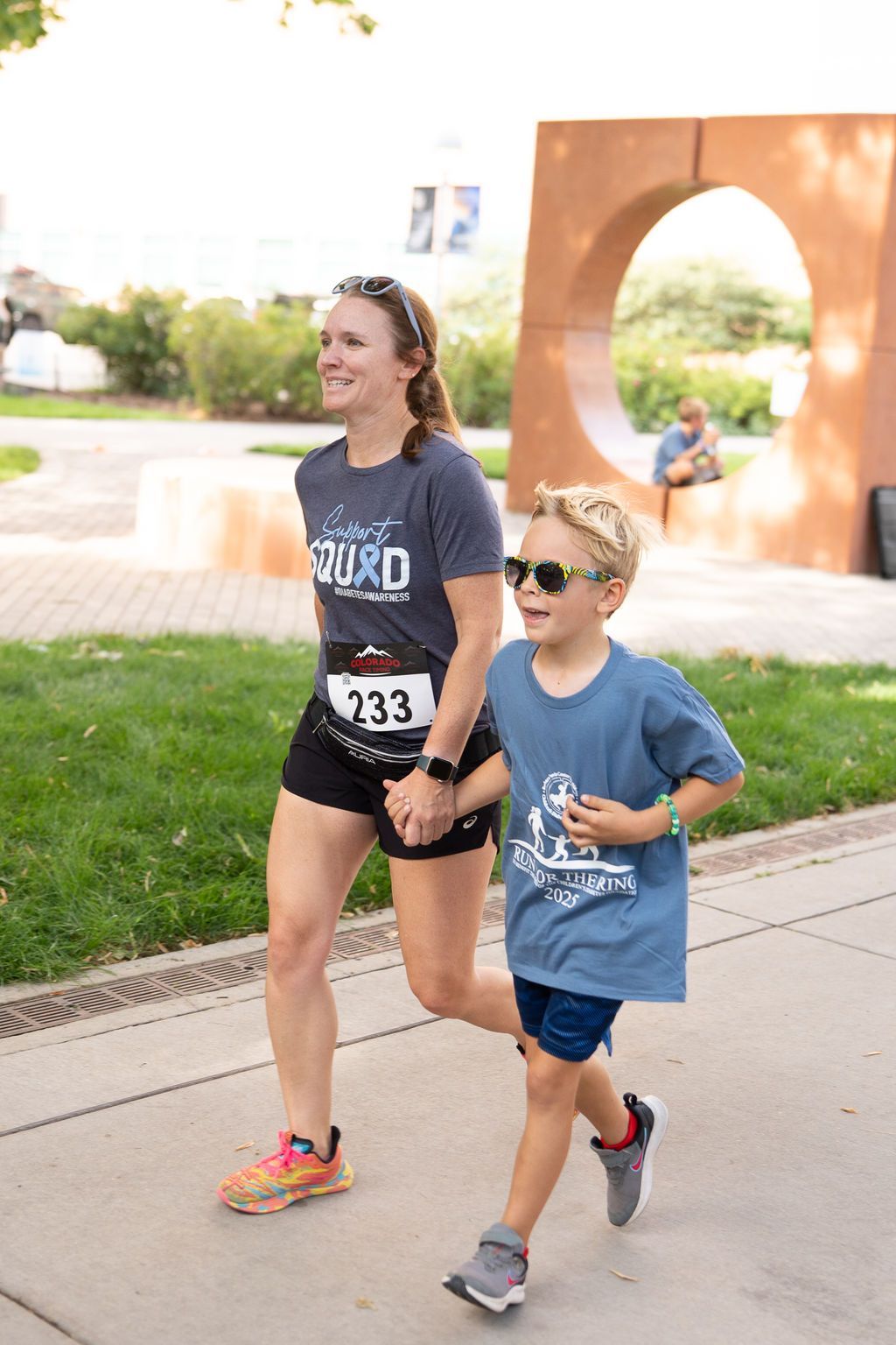 mother and young sun running race together and holding hands