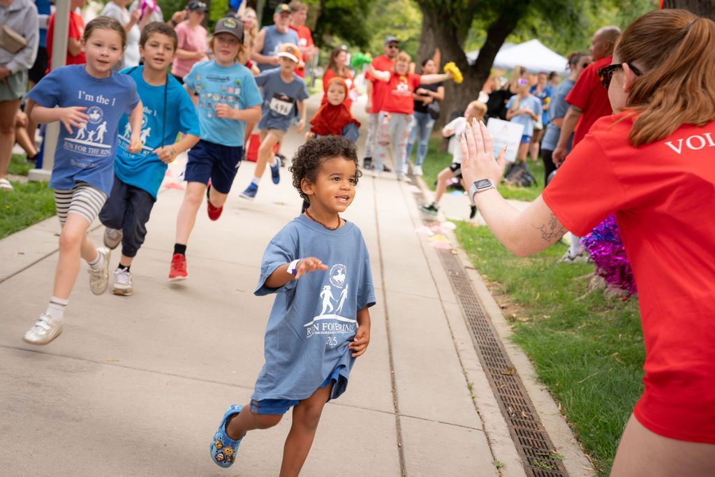 small boy giving a high five to a race volunteer