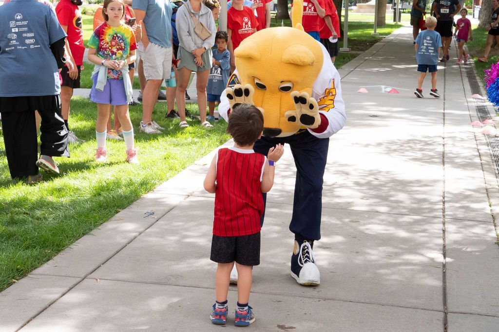 Denver Nuggets mascot Rocky giving high fives to small boy during kids fun run