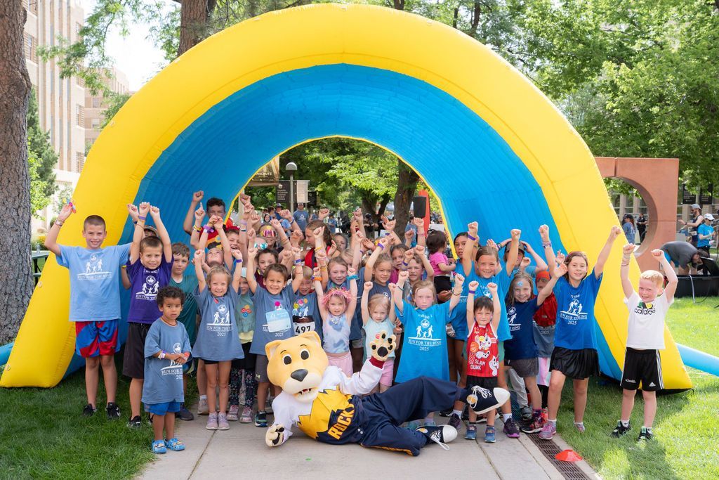 group of children at kids fun run race start under inflatable arch 