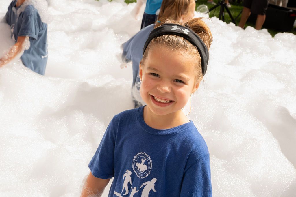 Young girl standing in pile of foam and smilin