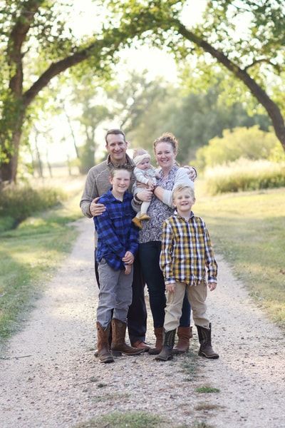 A family is posing for a picture on a dirt path.