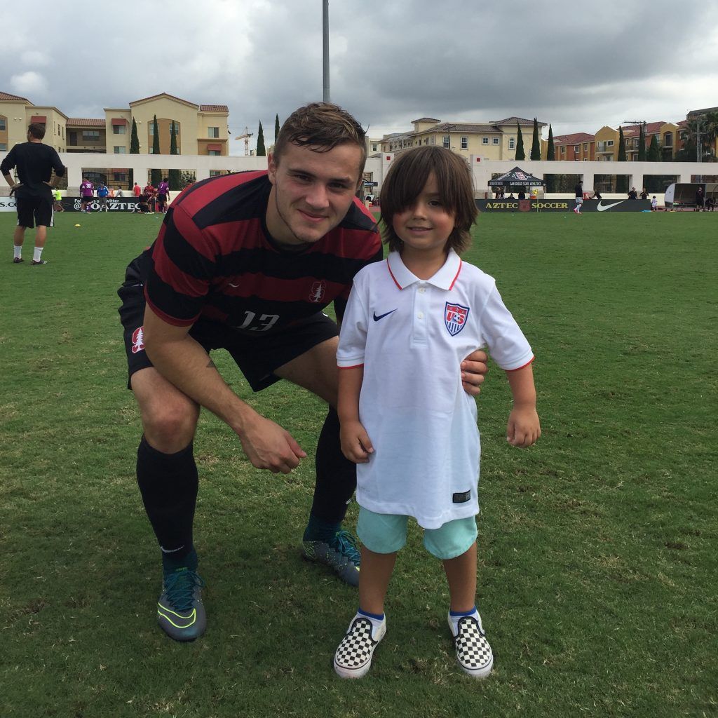 A man with the number 19 on his shirt is posing for a picture with a young boy