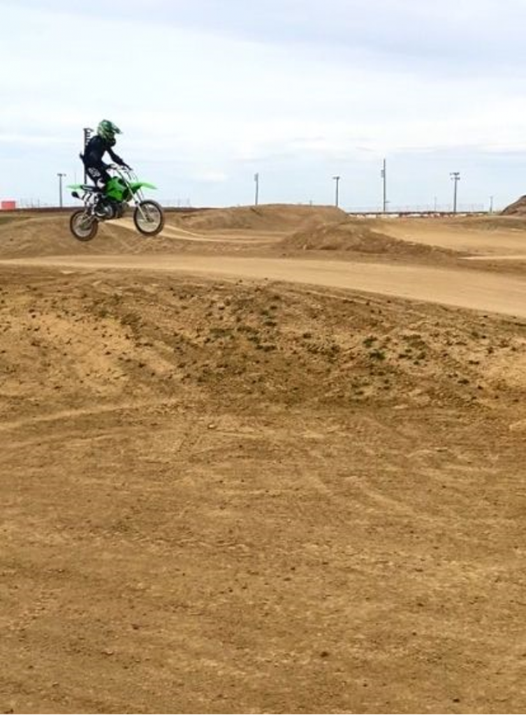A person is riding a dirt bike on a dirt track.