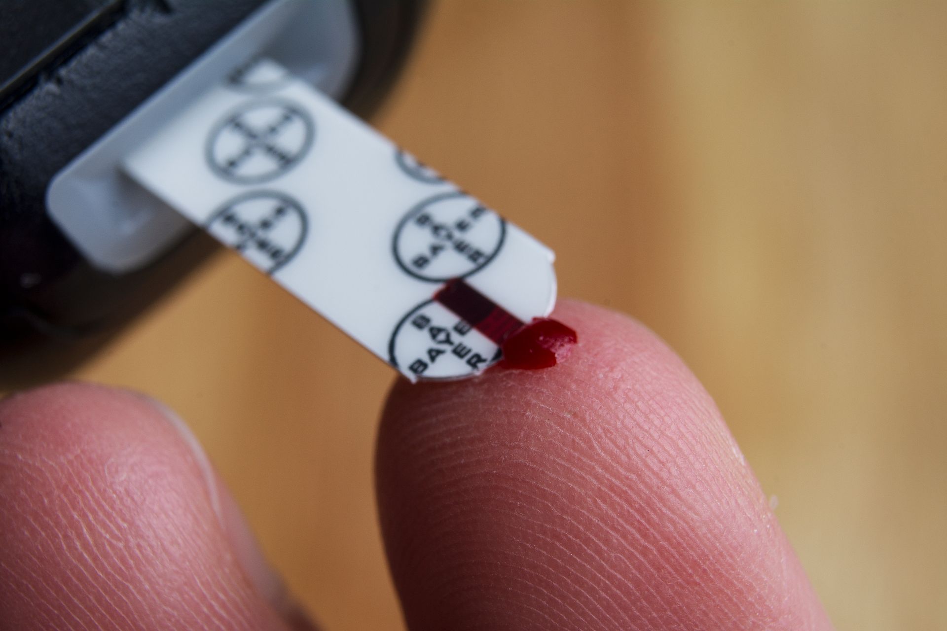 Closeup image of someone pricking their finger to test blood