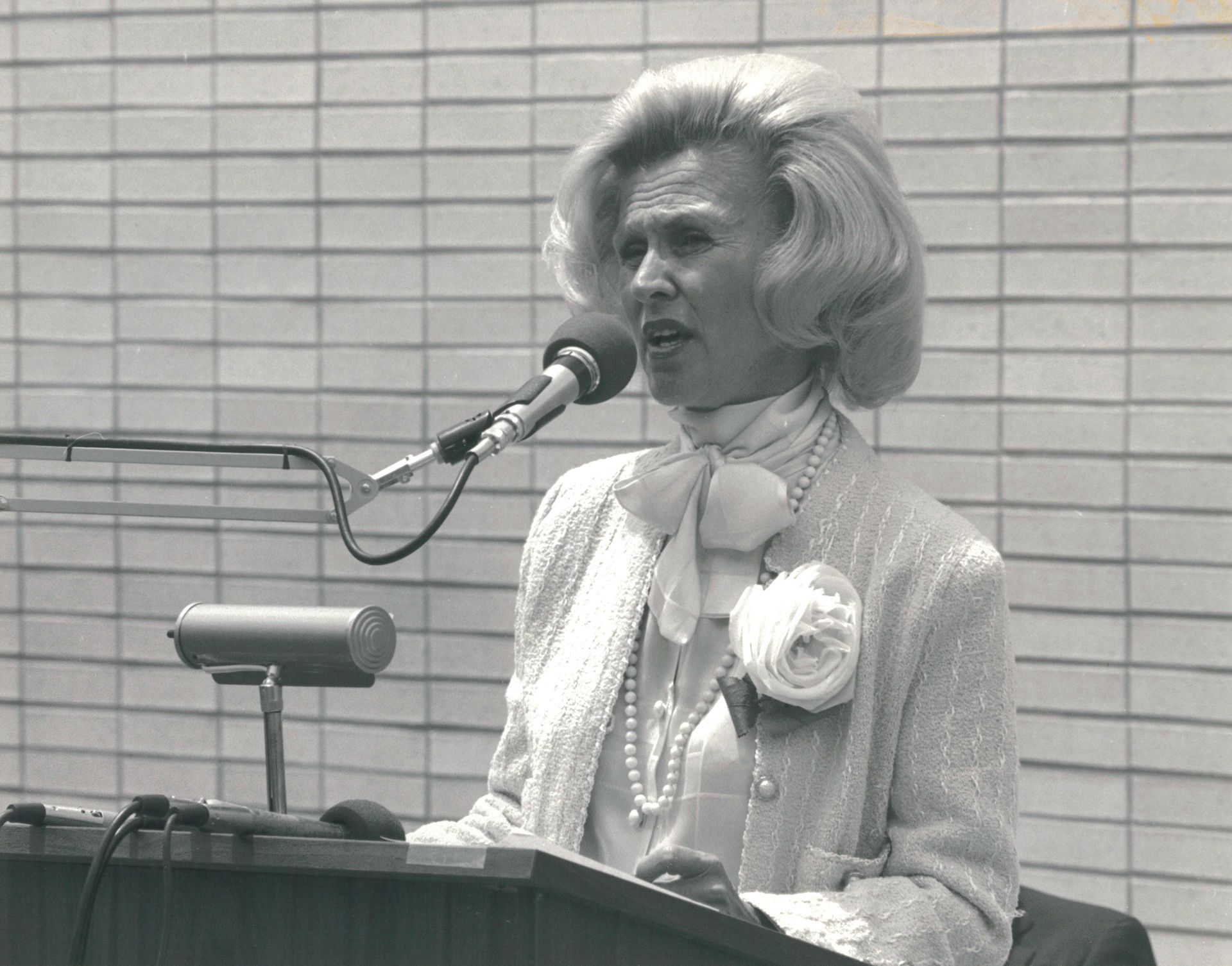 Barbara Davis speaking at a podium at the Dedication Ceremony of the BDC in 1984.